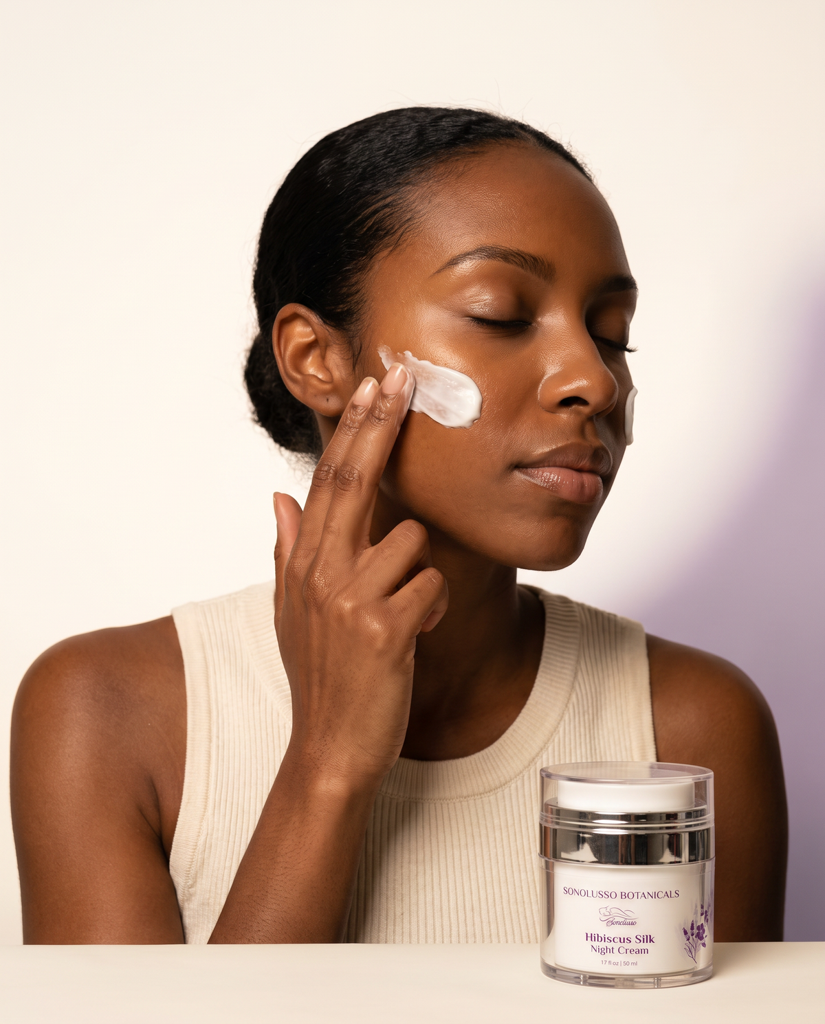 Hibiscus Silk Night Cream applied to the cheek — botanical night ritual